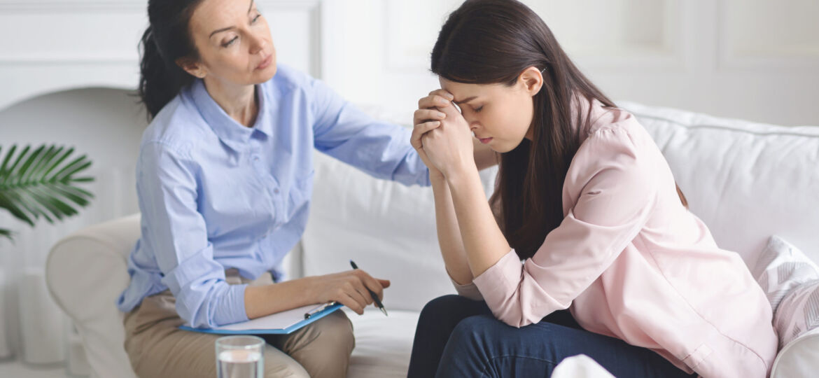 Therapist comforting her depressed crying woman patient